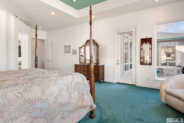 carpeted bedroom with a tray ceiling, crown molding, and access to exterior