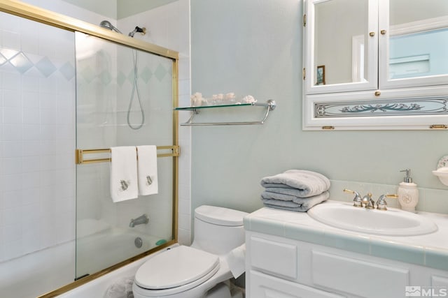 full bathroom with vanity, combined bath / shower with glass door, and toilet