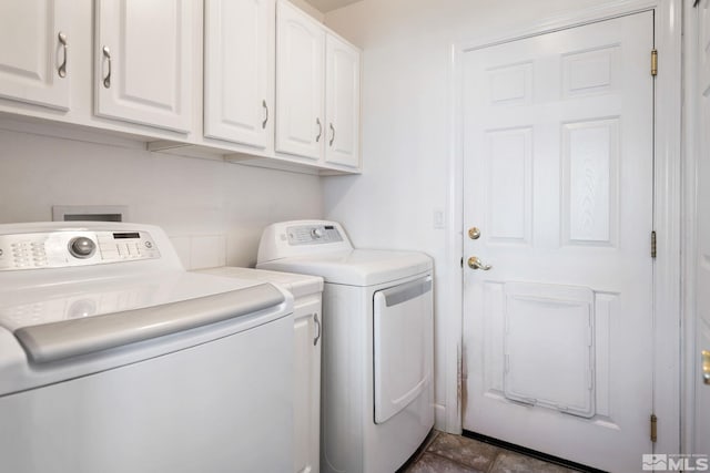 clothes washing area with washing machine and dryer and cabinets