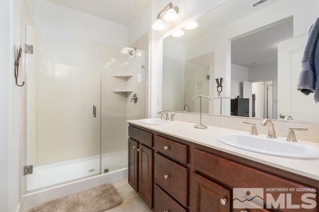 bathroom featuring a shower with shower door, vanity, and tile patterned floors