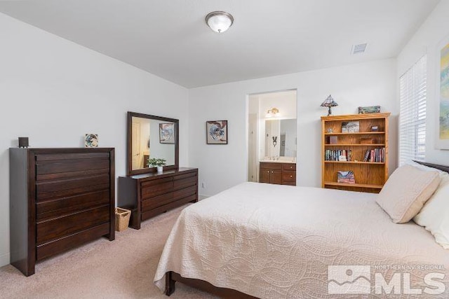 bedroom featuring light carpet and connected bathroom