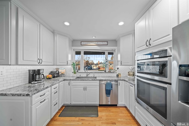 kitchen with stainless steel appliances, backsplash, and white cabinets