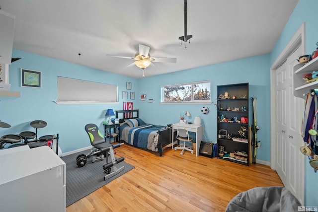 bedroom with ceiling fan, a closet, and light hardwood / wood-style floors