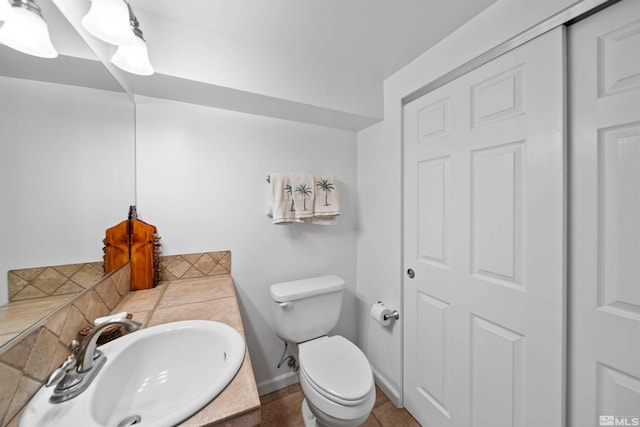 bathroom featuring toilet, tile patterned flooring, and vanity