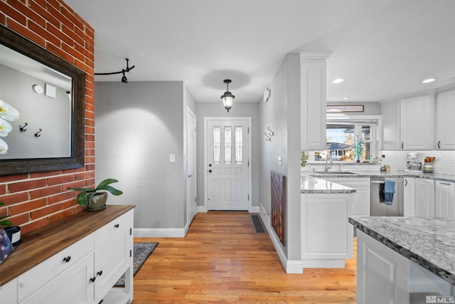 entryway with sink and light wood-type flooring