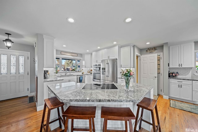 kitchen with a breakfast bar, white cabinetry, and stainless steel appliances