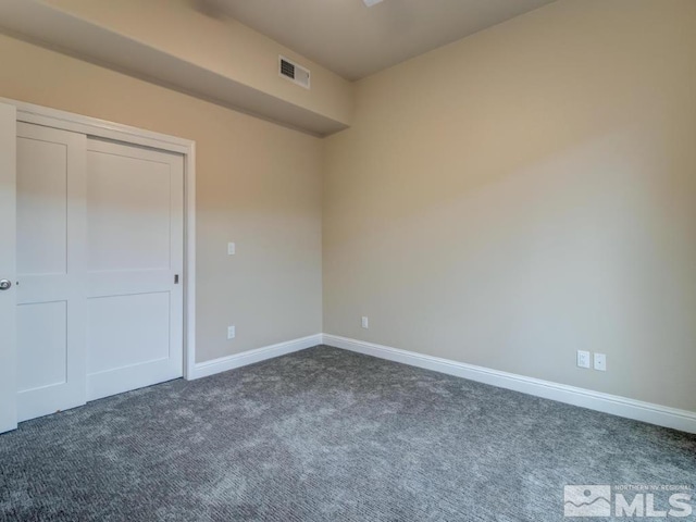 unfurnished room featuring dark carpet