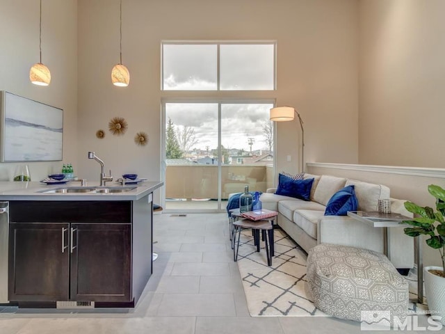 tiled living room with a high ceiling and sink