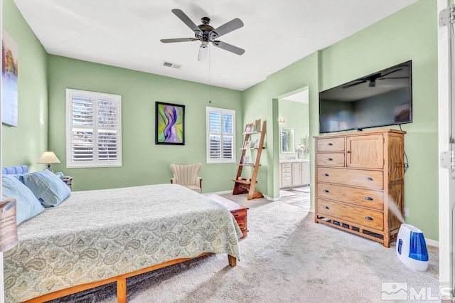 carpeted bedroom with ceiling fan and ensuite bathroom