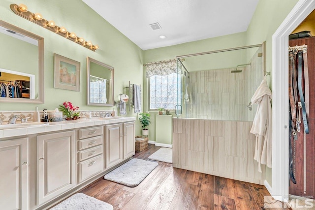 bathroom with vanity, a shower with door, and hardwood / wood-style flooring