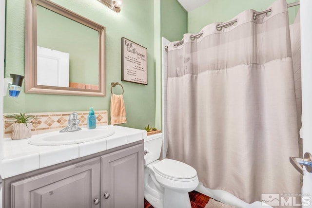 bathroom with toilet, tasteful backsplash, and vanity