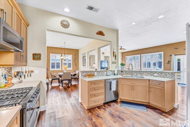 kitchen featuring kitchen peninsula, sink, light brown cabinets, and stainless steel appliances