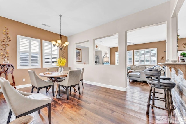 dining space with hardwood / wood-style flooring and an inviting chandelier