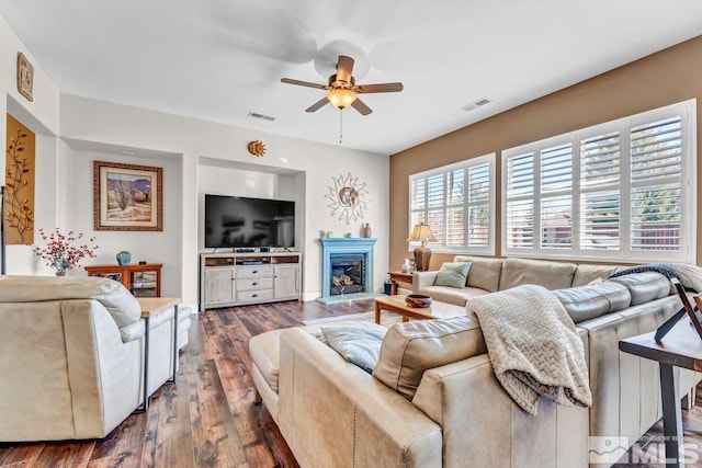 living room featuring ceiling fan and dark wood-type flooring