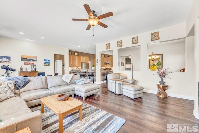 living room featuring ceiling fan with notable chandelier and hardwood / wood-style flooring