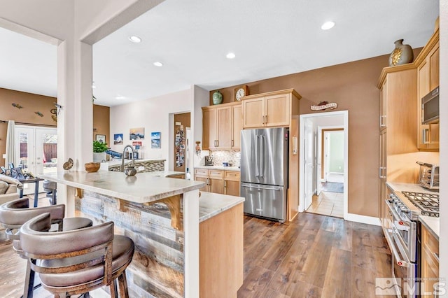 kitchen featuring light hardwood / wood-style floors, light brown cabinets, and high quality appliances