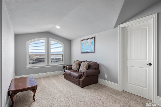 sitting room with lofted ceiling and light colored carpet