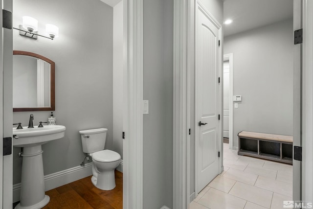 bathroom with toilet, tile patterned flooring, and sink