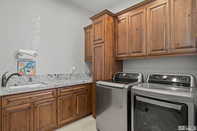 laundry room featuring light tile patterned floors, sink, separate washer and dryer, and cabinets