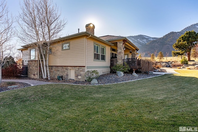 exterior space featuring a mountain view and a lawn