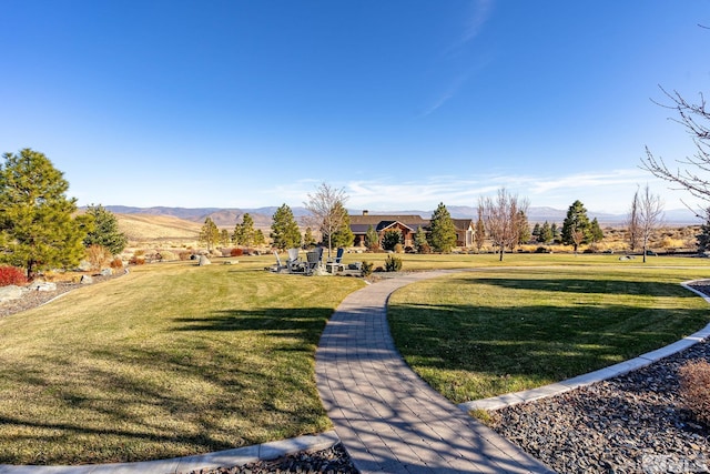 view of home's community with a mountain view and a yard