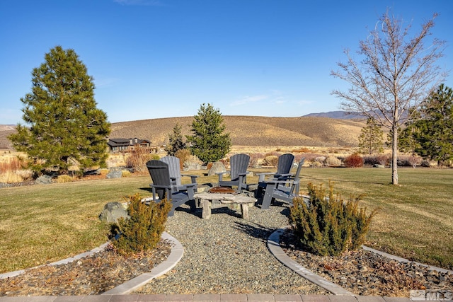 view of yard featuring an outdoor fire pit and a mountain view