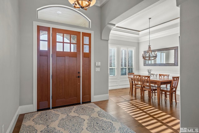 foyer entrance featuring wood-type flooring, a chandelier, and ornamental molding