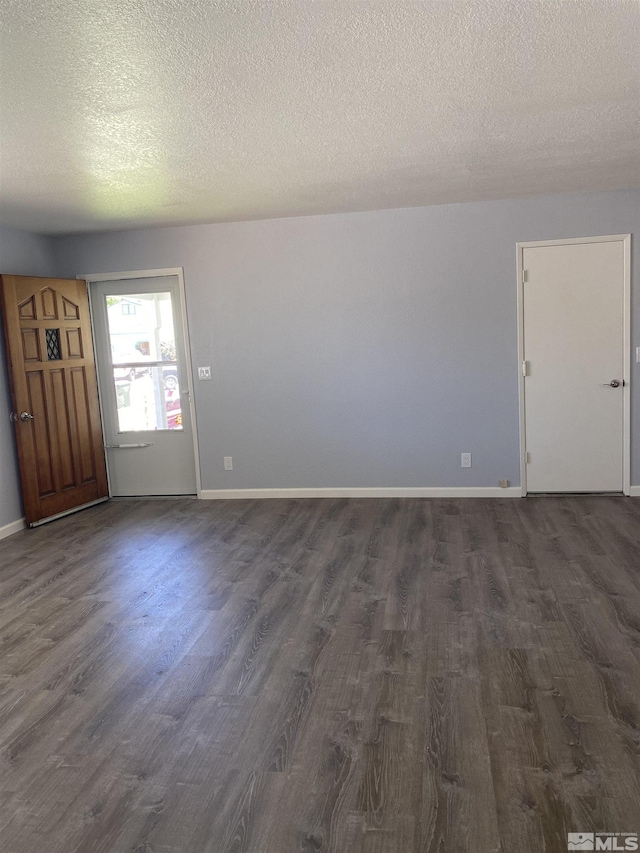 unfurnished room with dark hardwood / wood-style flooring and a textured ceiling