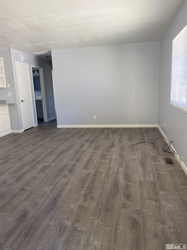 unfurnished room with dark hardwood / wood-style flooring and a textured ceiling