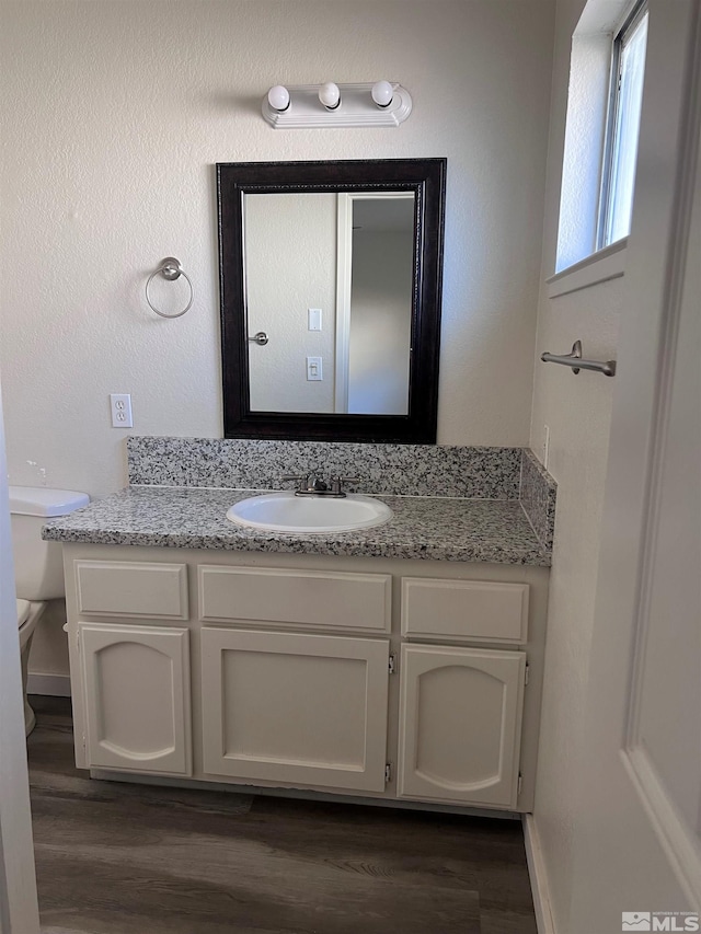 bathroom featuring hardwood / wood-style flooring, toilet, and vanity