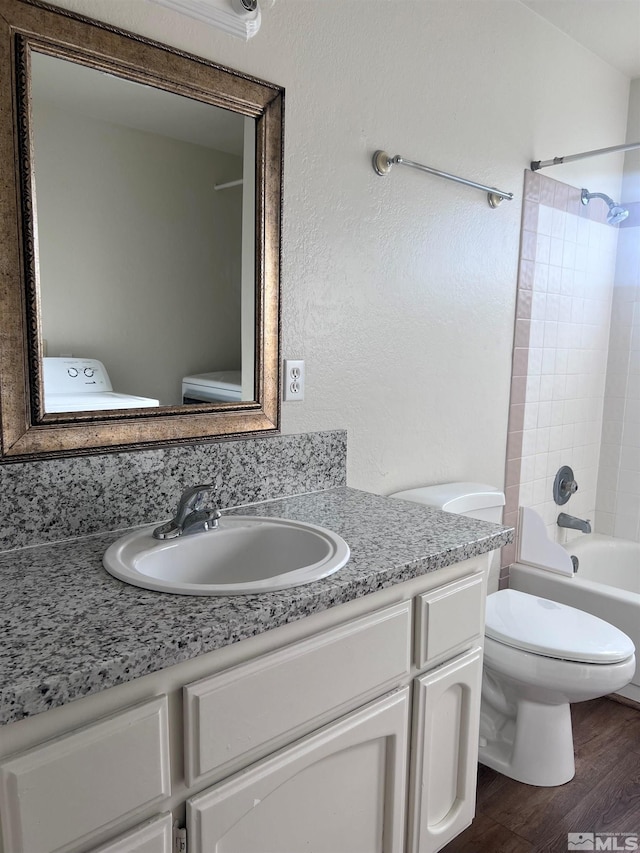 full bathroom featuring toilet, hardwood / wood-style flooring, vanity, and bathtub / shower combination