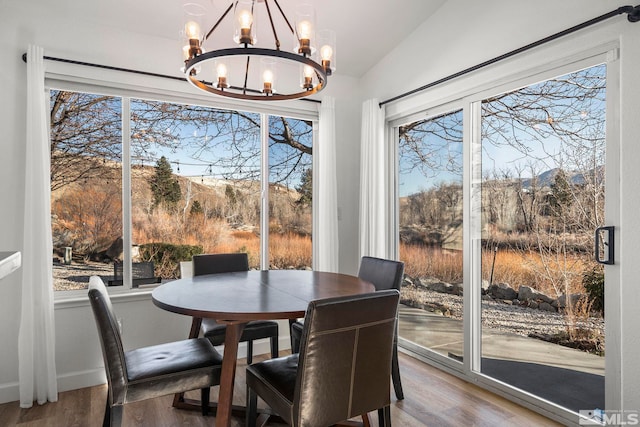 dining space featuring vaulted ceiling, an inviting chandelier, a mountain view, and hardwood / wood-style floors