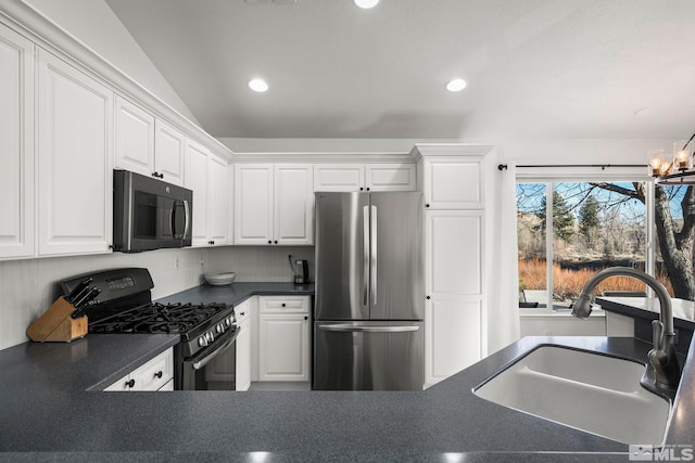 kitchen with sink, white cabinetry, stainless steel fridge, and gas stove