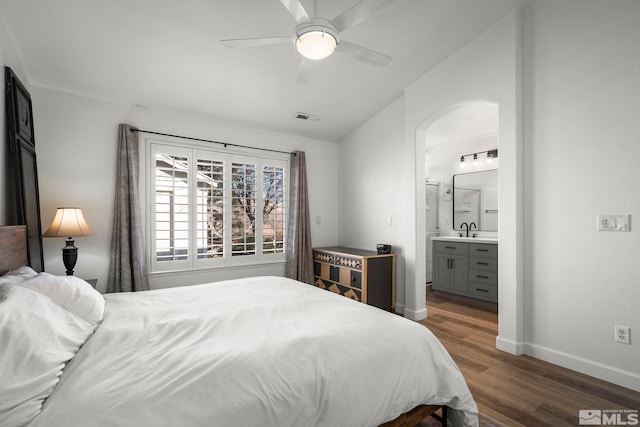 bedroom featuring ensuite bathroom, ceiling fan, lofted ceiling, sink, and dark hardwood / wood-style flooring