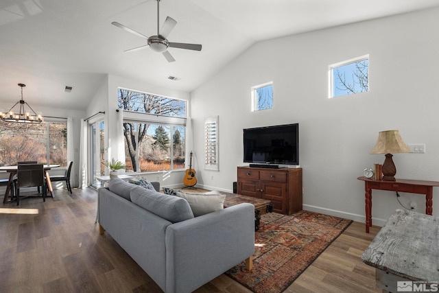 living room with ceiling fan with notable chandelier, hardwood / wood-style floors, and lofted ceiling