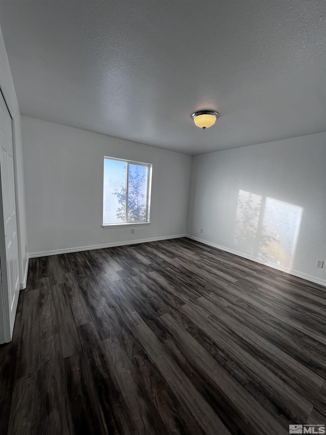 interior space with dark wood-type flooring and a textured ceiling