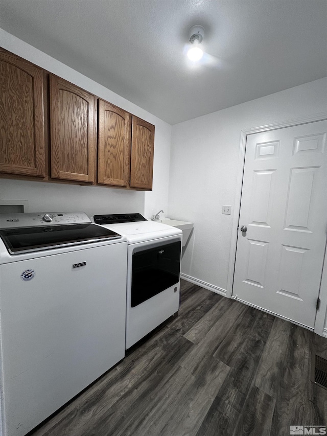 laundry room featuring cabinets, washer and dryer, dark hardwood / wood-style flooring, and sink