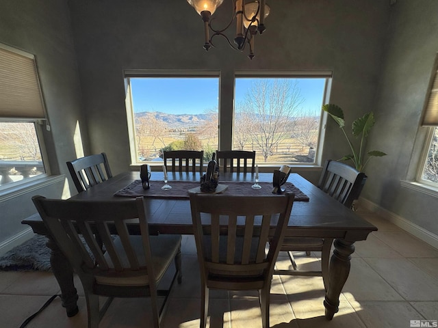 dining space with light tile patterned floors, an inviting chandelier, and a mountain view