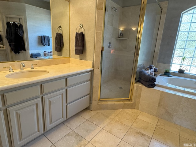 bathroom featuring plus walk in shower, vanity, and tile patterned flooring