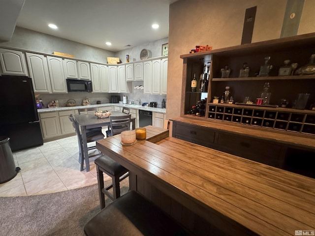 kitchen with sink, light tile patterned floors, and black appliances