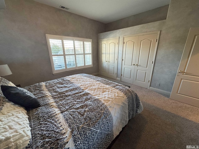 bedroom with carpet and two closets