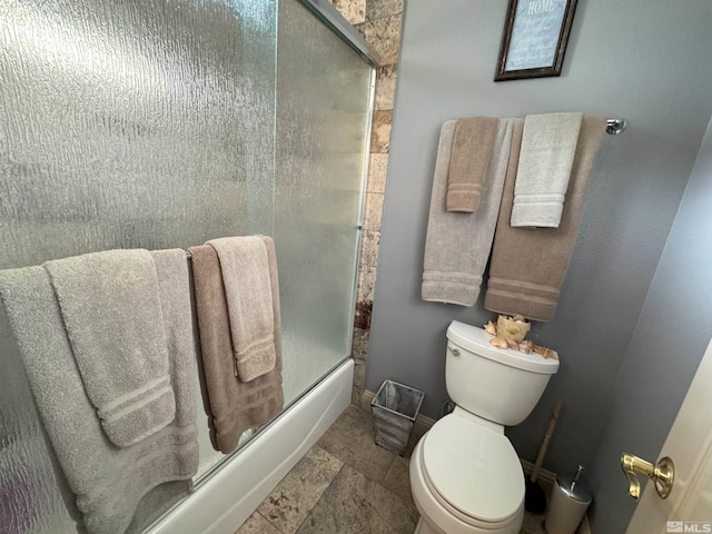 bathroom featuring enclosed tub / shower combo and toilet