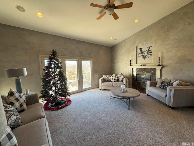 carpeted living room featuring ceiling fan, a premium fireplace, and high vaulted ceiling