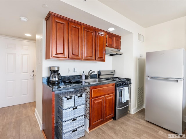 kitchen with fridge, light wood-type flooring, sink, and stainless steel range with gas stovetop