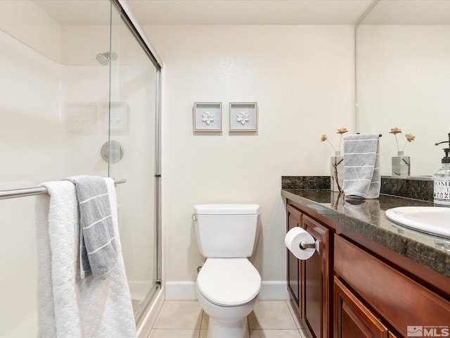 bathroom with an enclosed shower, vanity, toilet, and tile patterned flooring