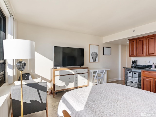 bedroom with light hardwood / wood-style floors and sink