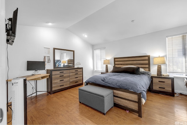 bedroom with lofted ceiling and light wood-type flooring