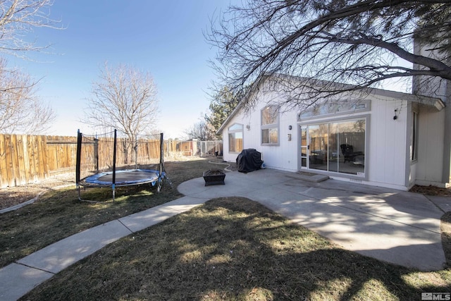 view of yard with a patio, a fire pit, and a trampoline