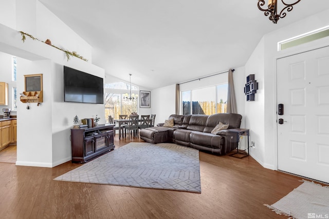 living room with dark wood-type flooring, a healthy amount of sunlight, and a notable chandelier