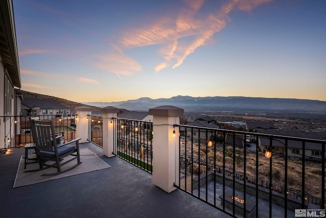 balcony at dusk featuring a mountain view